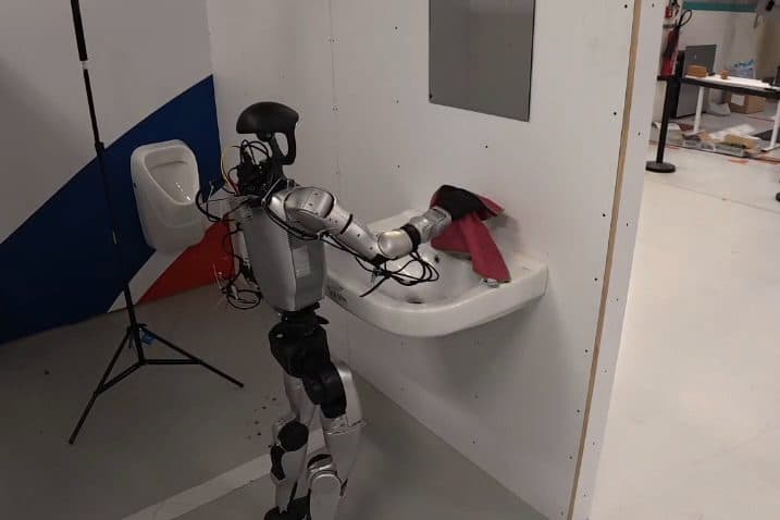 Humanoid wiping a sink with a cloth in the cleaning set-up on the HAC shop floor