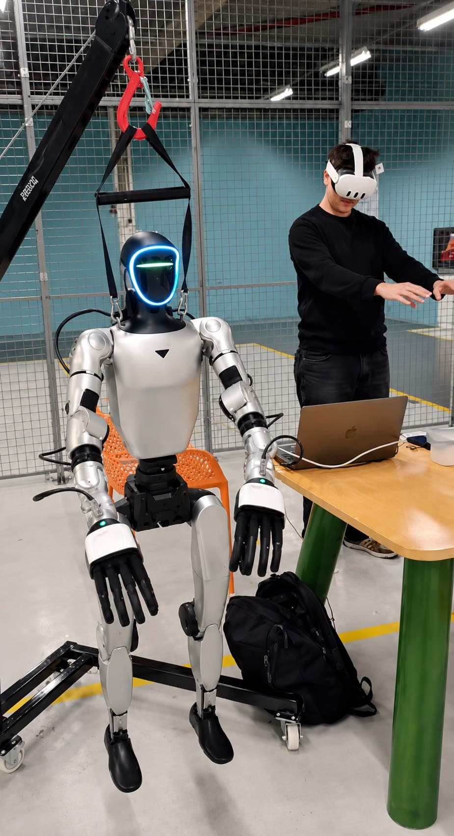 Engineer with VR headset operating a humanoid on the shop floor