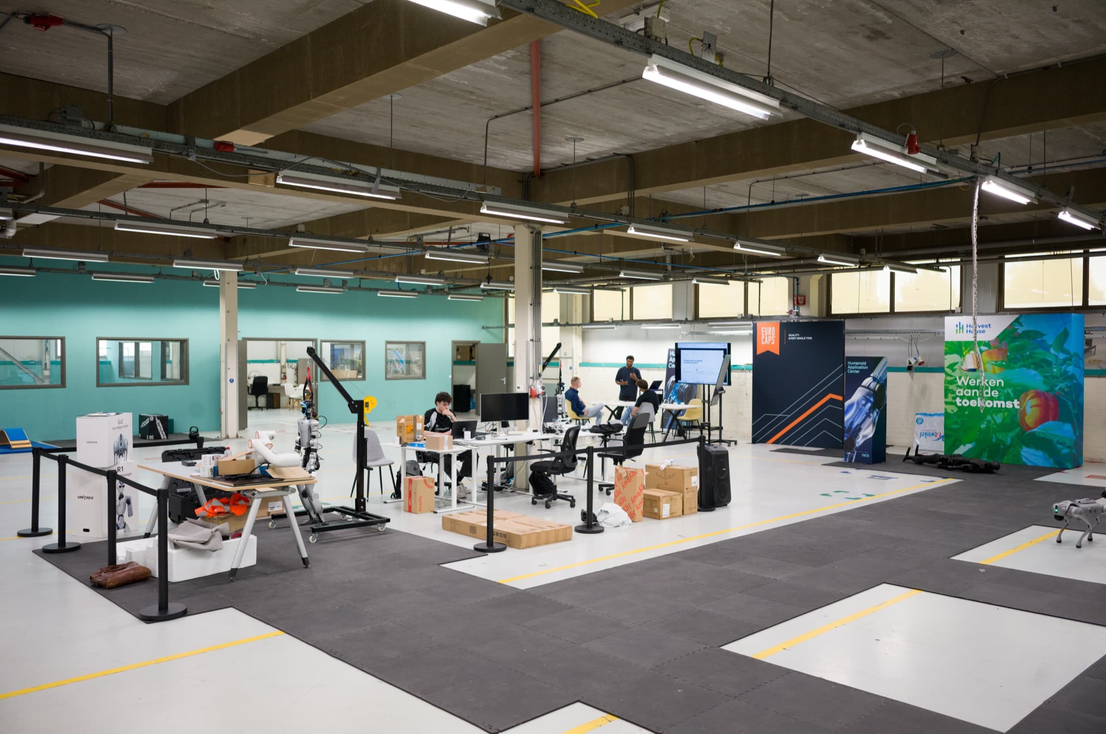 Overview of the HAC shop floor with desks, laptops, hoist frames, fall mats and robots